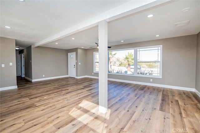 interior space featuring ceiling fan, beamed ceiling, and light wood-type flooring