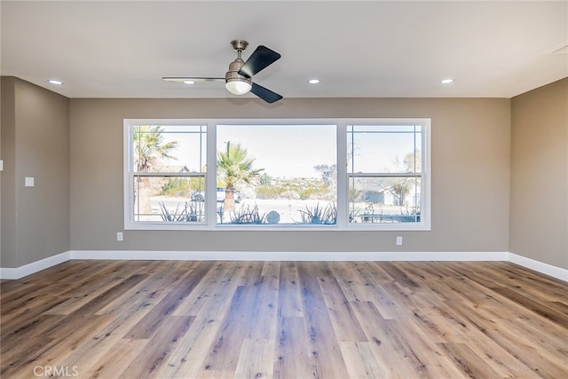 spare room featuring ceiling fan and light hardwood / wood-style floors