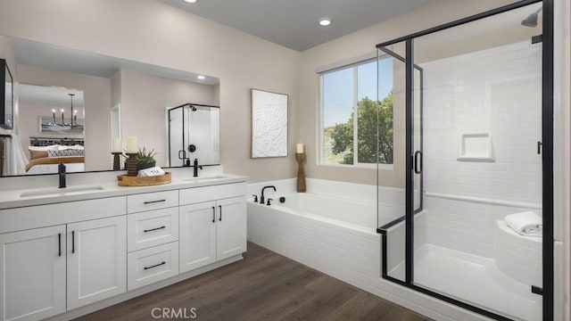 bathroom featuring vanity, a chandelier, plus walk in shower, and hardwood / wood-style floors