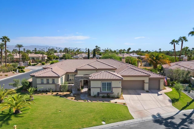 mediterranean / spanish house with a garage and a front lawn