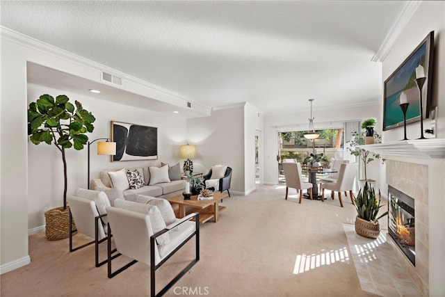 carpeted living room featuring a tile fireplace, a textured ceiling, and ornamental molding