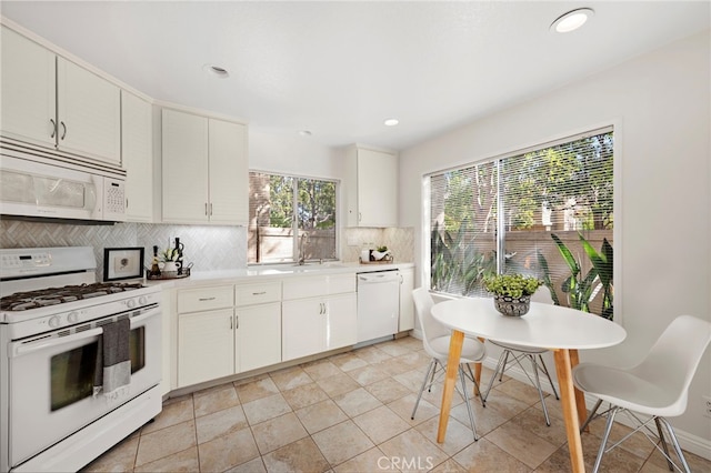 kitchen featuring white appliances, white cabinetry, light tile patterned flooring, and tasteful backsplash