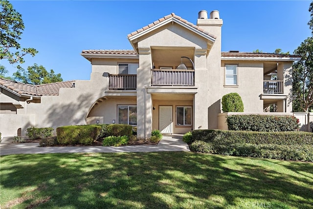 view of front of home featuring a balcony and a front yard