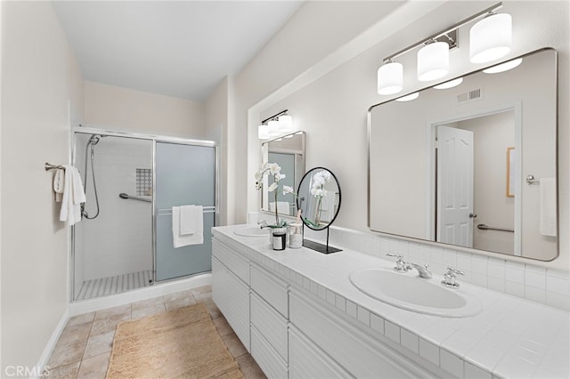 bathroom featuring vanity and a shower with shower door