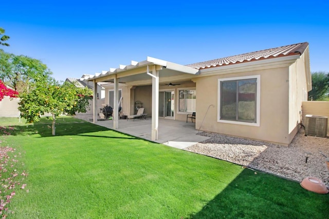 back of property with a lawn, ceiling fan, a patio, and central AC