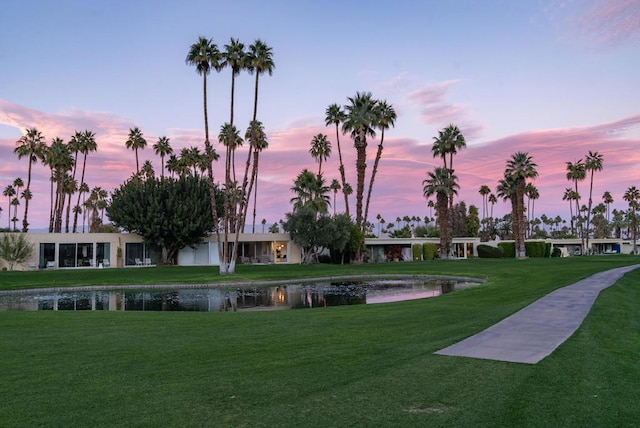 view of home's community with a water view and a lawn