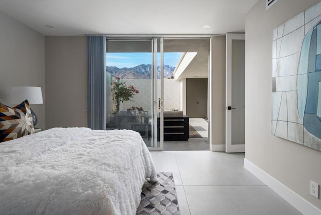 bedroom with access to outside, a wall of windows, tile patterned flooring, and a mountain view