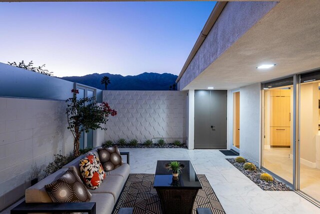 patio terrace at dusk featuring an outdoor hangout area and a mountain view