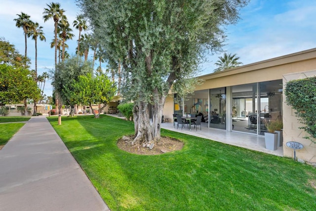 view of yard with ceiling fan and a patio