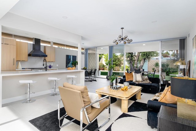 living room featuring sink, floor to ceiling windows, plenty of natural light, and a notable chandelier