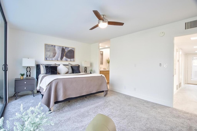 carpeted bedroom featuring ceiling fan and ensuite bath