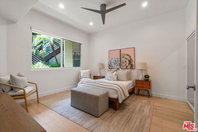 bedroom with ceiling fan and light hardwood / wood-style flooring