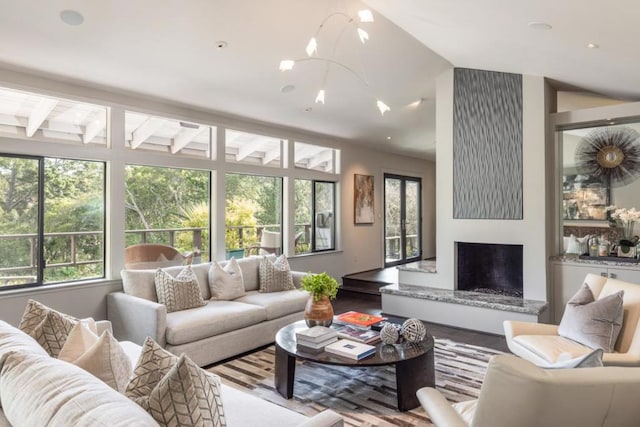 living room featuring lofted ceiling, wood-type flooring, and a wealth of natural light