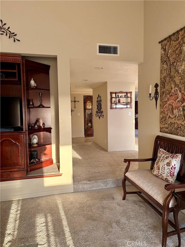 interior space featuring a towering ceiling and carpet flooring