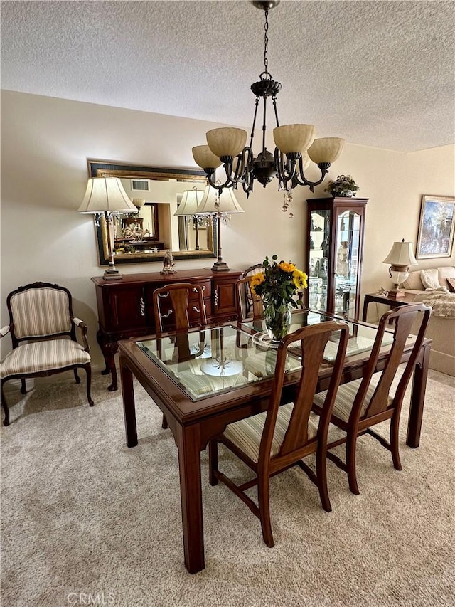 carpeted dining space featuring an inviting chandelier and a textured ceiling