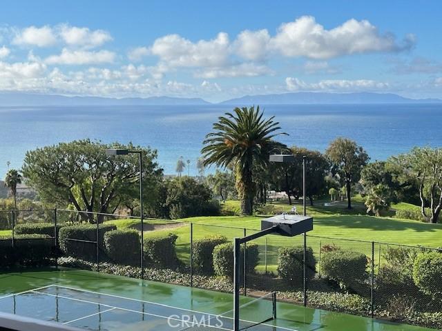 surrounding community with tennis court and a water view