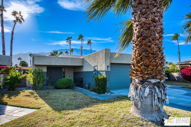 view of front of property featuring a mountain view, a garage, and a front yard