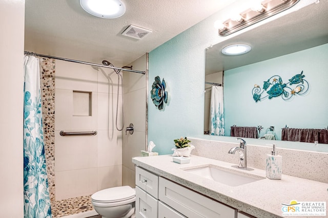 bathroom featuring vanity, a textured ceiling, toilet, and a shower with shower curtain