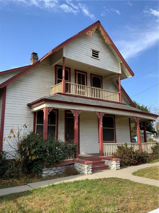 view of front of property with covered porch and a balcony