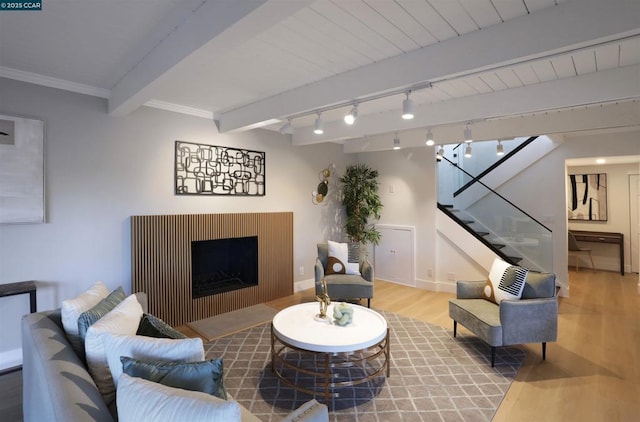 living room with track lighting, crown molding, hardwood / wood-style flooring, and beamed ceiling