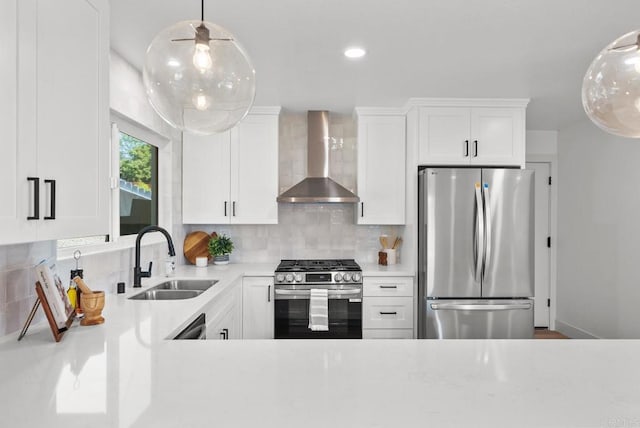 kitchen featuring sink, wall chimney range hood, stainless steel appliances, and white cabinetry