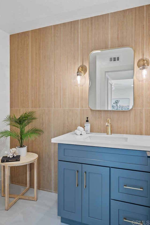 bathroom featuring vanity and wooden walls