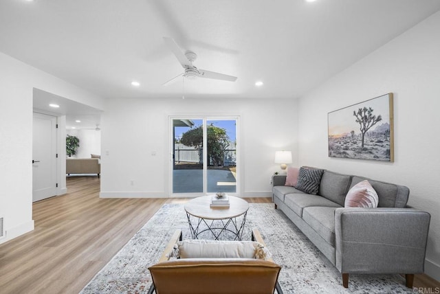 living room with ceiling fan and light hardwood / wood-style flooring