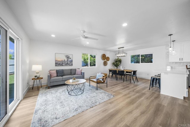 living room with ceiling fan and light wood-type flooring