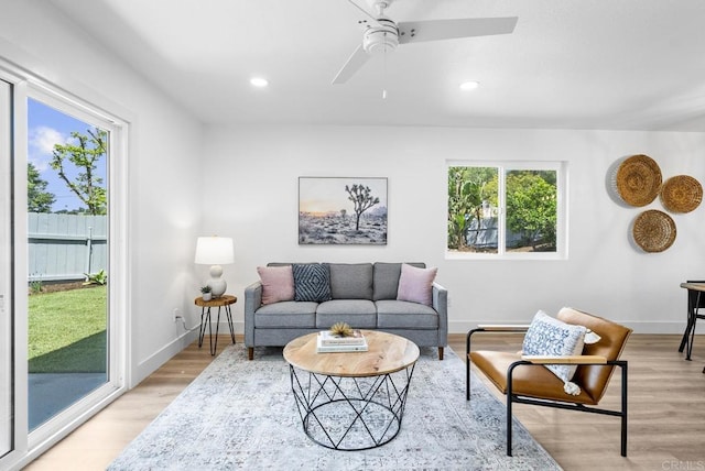 living area featuring recessed lighting, light wood-style floors, baseboards, and ceiling fan