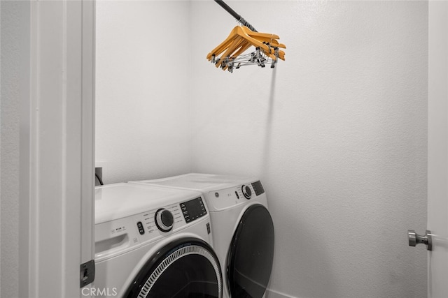 clothes washing area with separate washer and dryer