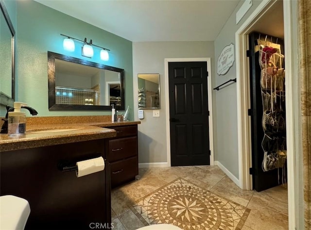 bathroom with toilet, a shower, and vanity