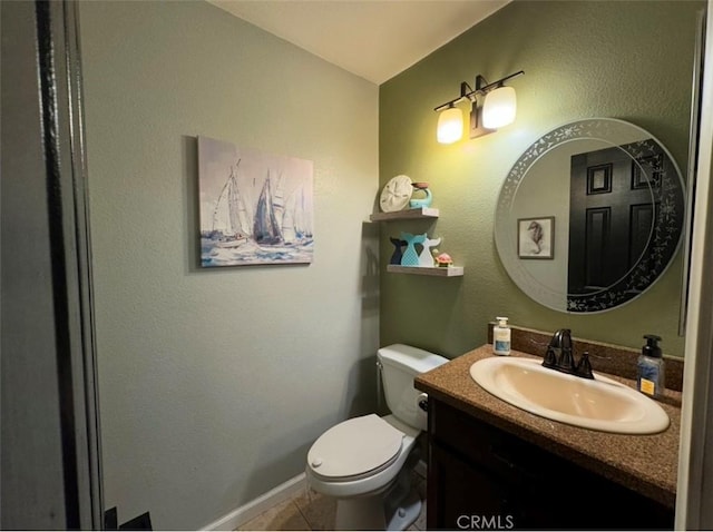 bathroom with toilet, vanity, and tile patterned flooring