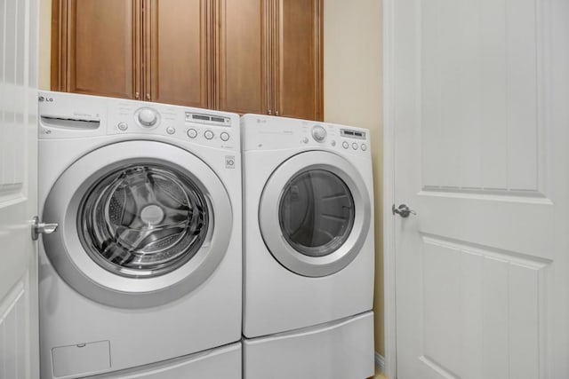 washroom featuring independent washer and dryer and cabinets