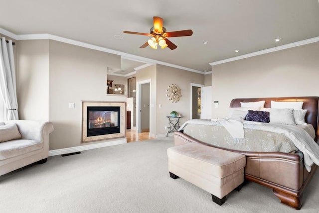 bedroom with ceiling fan, ornamental molding, and carpet floors