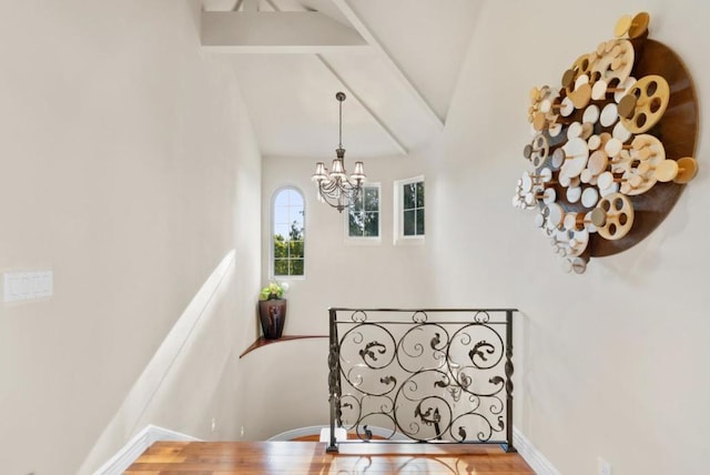 staircase featuring hardwood / wood-style flooring, vaulted ceiling with beams, and a chandelier