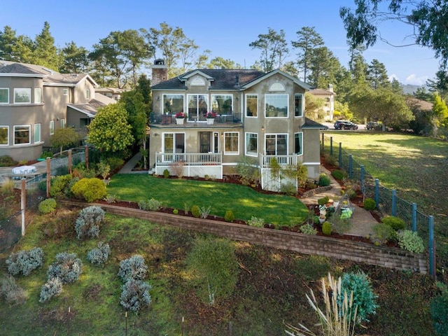 view of front of house with a porch, a balcony, and a front lawn