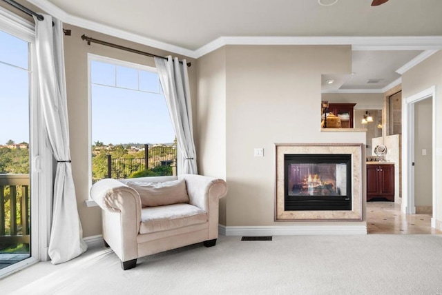 living area featuring crown molding, a fireplace, and light colored carpet