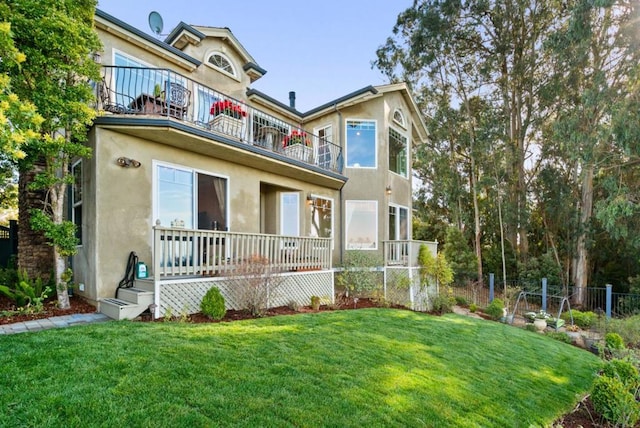 view of front of house with a balcony and a front lawn