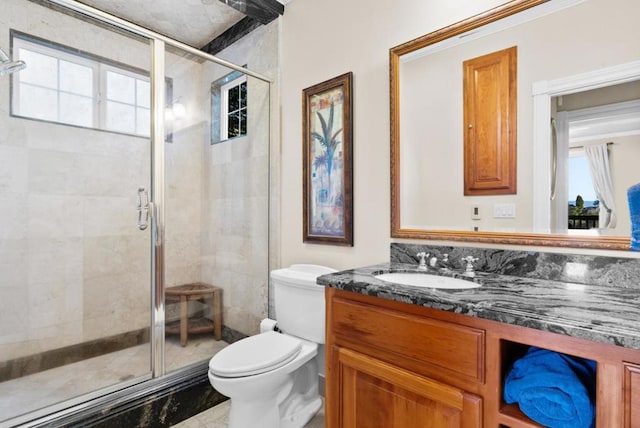 bathroom with walk in shower, vanity, and toilet