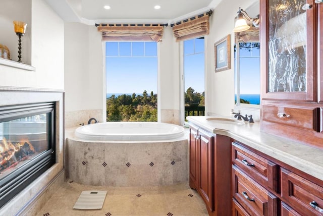 bathroom featuring vanity, a relaxing tiled tub, and tile patterned floors