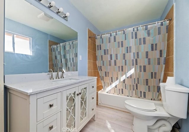 full bathroom featuring toilet, hardwood / wood-style flooring, shower / bath combo with shower curtain, and vanity