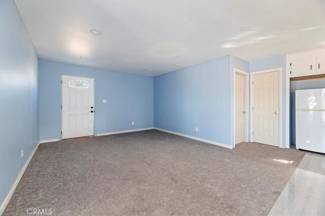 unfurnished living room featuring light carpet