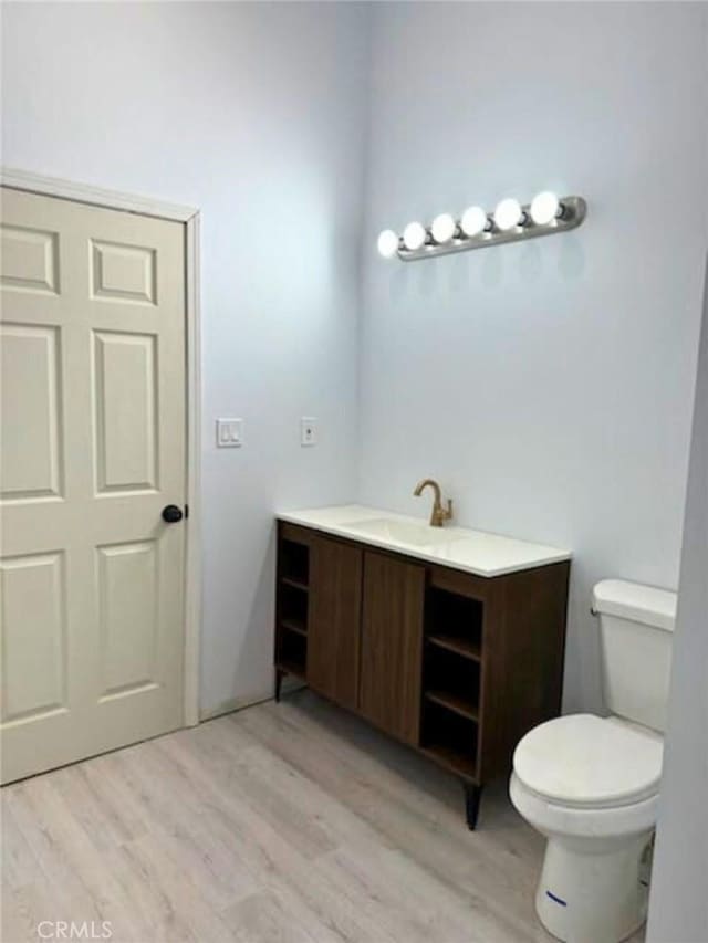 bathroom featuring hardwood / wood-style flooring, toilet, and vanity