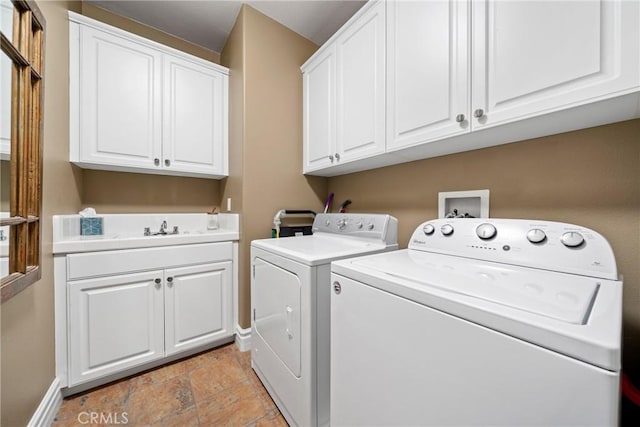 clothes washing area with sink, separate washer and dryer, and cabinets