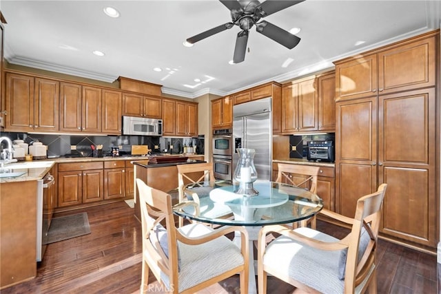 kitchen with crown molding, stainless steel appliances, decorative backsplash, and dark hardwood / wood-style floors