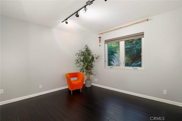 unfurnished room featuring rail lighting and wood-type flooring