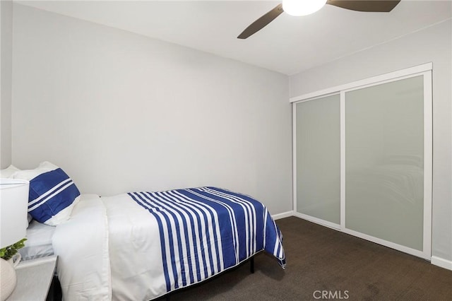 carpeted bedroom featuring ceiling fan and a closet