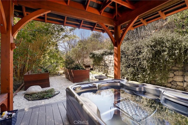 view of patio with a hot tub and a deck