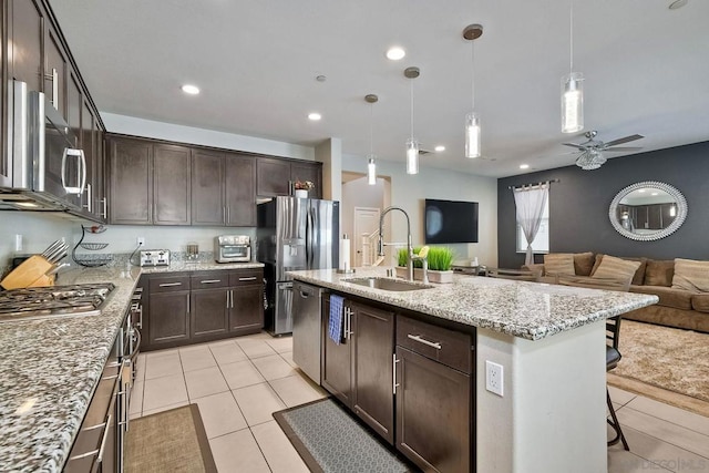 kitchen with pendant lighting, sink, an island with sink, a kitchen breakfast bar, and stainless steel appliances