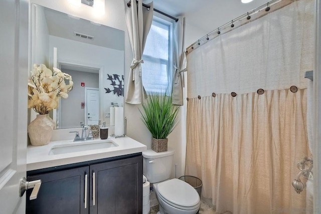 bathroom featuring toilet, a shower with shower curtain, and vanity